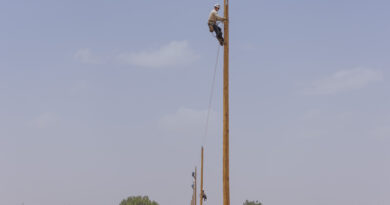 A photo of CPS Energy erecting a line of electric poles